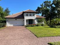 Charming single-story home with a clay tile roof, brick driveway, and well-manicured lawn at 3609 Azurite Ct, Deland, FL 32724