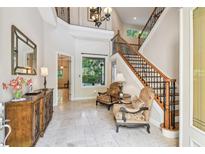 Grand foyer with staircase, tile flooring, and sitting area, offering a welcoming entrance at 755 Cranes Court, Maitland, FL 32751