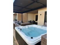 Inviting hot tub with lounge seating and dining area under a covered patio at 7567 Brooklyn Dr, Kissimmee, FL 34747