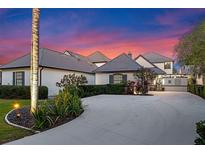 Beautiful exterior elevation of home with a circular drive, landscaping, and a stunning sunset sky at 9624 Bryanston Dr, Orlando, FL 32827