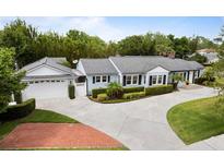 Charming home with a well-manicured lawn, complemented by a long driveway and lush landscaping at 1702 N Westmoreland Dr, Orlando, FL 32804