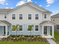 Charming two-story townhome featuring a well-maintained lawn and decorative landscaping at 4216 Sadler Rd, Apopka, FL 32712