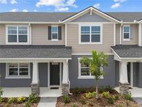 Charming townhouse featuring a well-manicured lawn and inviting front entrance with decorative stone pillar accents at 4236 Sadler Rd, Apopka, FL 32712