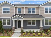 Charming two-story townhome featuring a welcoming front porch and well-maintained landscaping at 4244 Sadler Rd, Apopka, FL 32712