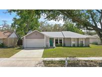 Charming home featuring a well-maintained front yard, driveway, garage, and a welcoming front door at 5163 Lighthouse Rd, Orlando, FL 32808