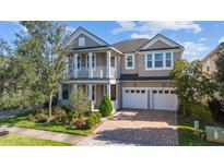 Charming two-story home with a brick driveway, a two-car garage, and a lovely second story balcony at 8565 Tallfield Ave # 1, Orlando, FL 32832