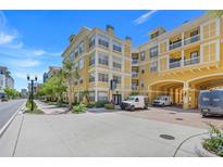 Street view of yellow condo building with breezeway, sidewalk and landscaping at 860 N Orange Ave # 226, Orlando, FL 32801