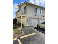 Two-story condo featuring an attached garage and private balcony, enhancing its curb appeal at 1001 Spring Meadow # 1001, Kissimmee, FL 34741