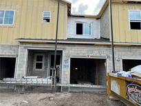 Unfinished exterior of a townhouse with block and siding construction, awaiting completion at 14934 Harvest St, Orlando, FL 32824