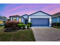 Charming single Gathering home featuring a two-car garage, well manicured lawn, and unique blue trim at 2308 Glenbrook Chase Blvd, Lakeland, FL 33811