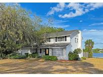 Charming two-story home with a brick facade and a well-maintained yard overlooking a serene lake at 240 Slade Dr, Longwood, FL 32750