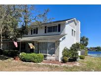 Two-story home with white siding, brick accents, bay window, and mature landscaping at 240 Slade Dr, Longwood, FL 32750