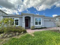 Charming single-story home featuring a well-manicured lawn and a welcoming front entrance with stone accents at 2741 Nottel Dr, St Cloud, FL 34772