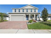 Charming two-story home with a brick driveway, two-car garage and manicured landscaping at 2965 Slough Creek Dr, Kissimmee, FL 34744