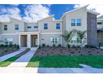 Inviting townhome exterior with manicured landscaping, modern design and a stone accent wall detail at 4188 Paragraph Dr, Kissimmee, FL 34746