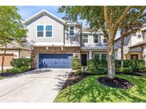 Charming two-story home featuring a blue garage door, brick accents, and a well-manicured lawn at 540 Seven Oaks Blvd, Winter Springs, FL 32708