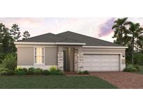 Charming single-story home featuring a two-car garage and well-manicured lawn at 7138 Rolling Leaf Rd, Groveland, FL 34736