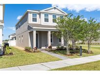 Charming two-story home featuring a landscaped front yard with fresh green grass and healthy trees at 779 Firerock Ln, Debary, FL 32713