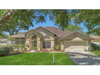 Charming single-story home featuring a well-manicured lawn and mature trees, plus a two-car garage at 8061 Bangle Ln, Orlando, FL 32836