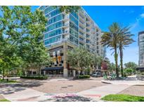 Modern condo building featuring multiple stories with balconies and street-level retail space at 101 S Eola Dr # 1018, Orlando, FL 32801