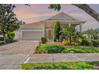 Charming single-story home with a screened porch, two-car garage, and lush landscaping at 115 Crescent Moon Dr, Groveland, FL 34736