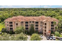 Beautiful Tuscan-style condo building with a red tile roof and lush landscaping at 1375 Tuscana Ln # 1408, Davenport, FL 33896