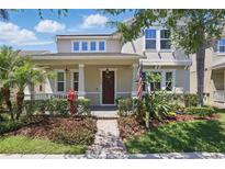 Charming two-story home featuring a landscaped yard, inviting front porch, and classic architectural details at 14838 Bahama Swallow Blvd, Winter Garden, FL 34787