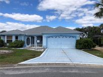 Charming single-story home featuring a well-manicured lawn and a two-car garage at 1805 San Luis Ln, The Villages, FL 32159
