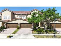 Beautiful townhome featuring a red tile roof, brown garage doors, and a paver driveway at 2167 Velvet Leaf Dr, Ocoee, FL 34761