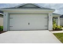 This home features a spacious two-car garage with carriage accents and a concrete driveway at 2607 Tulip Dr, Davenport, FL 33837