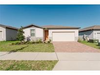 Charming single-story home featuring a brick driveway, two-car garage, and well-manicured lawn at 349 Guadlupe St, Haines City, FL 33844