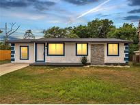 Charming single-story home with white stucco, blue trim, and well-manicured lawn at 358 Prevo Dr, Apopka, FL 32712