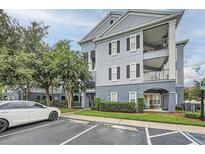 Attractive multi-story condo building with a parking lot, landscaping, and classic architectural details at 3621 Conroy Rd # 738, Orlando, FL 32839