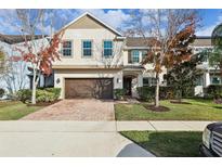 Charming two-story home boasts a well-maintained lawn, mature landscaping and a brick paved driveway leading to a two-car garage at 611 Marsh Reed Dr, Winter Garden, FL 34787