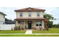 Charming two-story home featuring a cozy front porch and well-manicured lawn at 900 S Maple Ave, Sanford, FL 32771