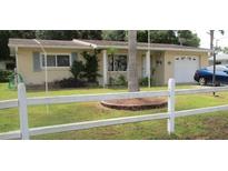 Charming single-story home with a well-maintained front yard, fenced in with an attached garage at 116 E Palm Way, Edgewater, FL 32132