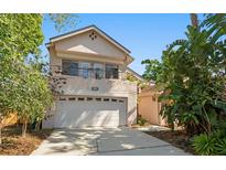 Charming two-story home with a two-car garage and tropical landscaping at 1450 Harbour Dr, Longwood, FL 32750
