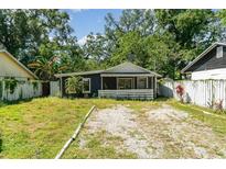 Charming one-story home with a gravel driveway, surrounded by mature trees and lush greenery at 1506 37Th St, Orlando, FL 32839
