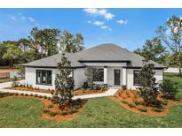 Stunning single story home featuring manicured lawn, mulched flower beds, and a dark-trimmed facade at 18026 Reynolds Pkwy, Orlando, FL 32833