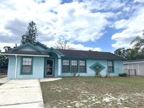 Charming single-story home with a light blue exterior and well-maintained lawn at 2322 Vincent Rd, Orlando, FL 32817