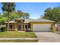 Charming single-story home with mature landscaping, a large driveway, and a two-car garage at 4371 Vestawood Ct, Sanford, FL 32773