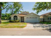 Charming single-story home with a well-maintained lawn, two-car garage, and beautiful mature trees at 4522 Weeping Willow Cir, Casselberry, FL 32707