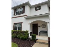 Charming two-story home featuring a covered entrance with a bench and meticulously maintained landscaping at 4800 Lullaby Ln, Kissimmee, FL 34746