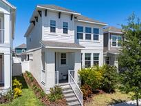 Charming two-story home with white siding, a welcoming front porch, and well-maintained landscaping at 15408 Lebeau Loop, Winter Garden, FL 34787