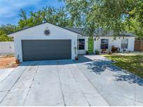 Charming single-story home featuring a gray two-car garage and a bright green front door at 194 Larkspur Ct, Kissimmee, FL 34743