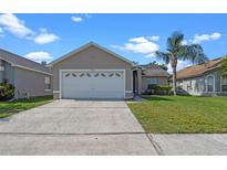 Charming single-story home featuring a concrete driveway, a two-car garage and a well-manicured lawn at 3220 Harpers Ferry Ct, Orlando, FL 32837