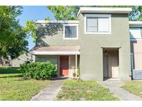 Charming two-story townhome featuring a textured exterior and cozy front porch at 5961 Windhover Dr # F05, Orlando, FL 32819