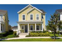 Charming two-story home with a welcoming front porch, lush landscaping, and a well-maintained lawn at 7409 Inlet Pt, Celebration, FL 34747