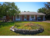 Charming single-story brick home featuring a well-maintained front yard, carport, and classic architectural details at 1 Cosmos Dr, Orlando, FL 32807