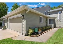 Attractive townhome showcasing a tidy yard, updated siding, and an attached garage at 35 Misners Trl, Ormond Beach, FL 32174